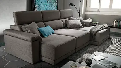 divano elegante di colore grigio con sedute estraibili e poggiatesta reclinabili.