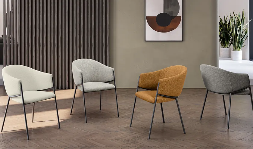 Sedia disponibile in vari colori, con seduta in tessuto bouclé easy-clean e struttura in metallo verniciato.